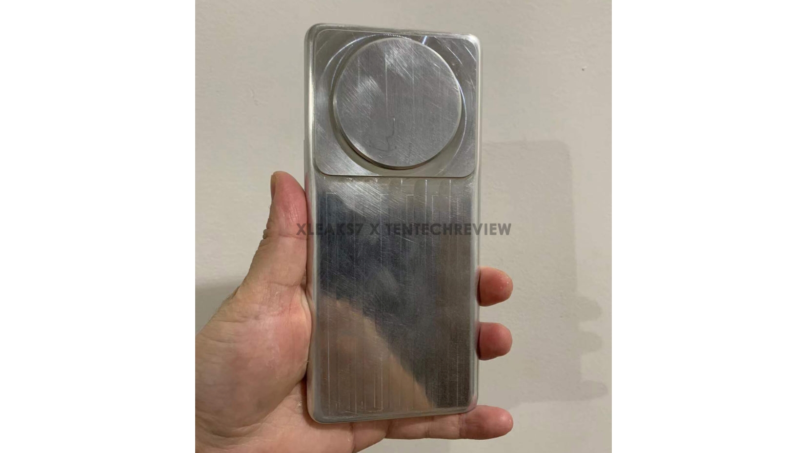 An aluminum dummy unit of the Xiaomi 12 Ultra held in someone's hand