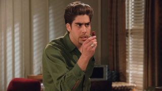 Adam Goldberg, as Eddie, holds up a dehydrated fruit in the Friends Season 2 episode The Won't Where Eddie Won't Go.