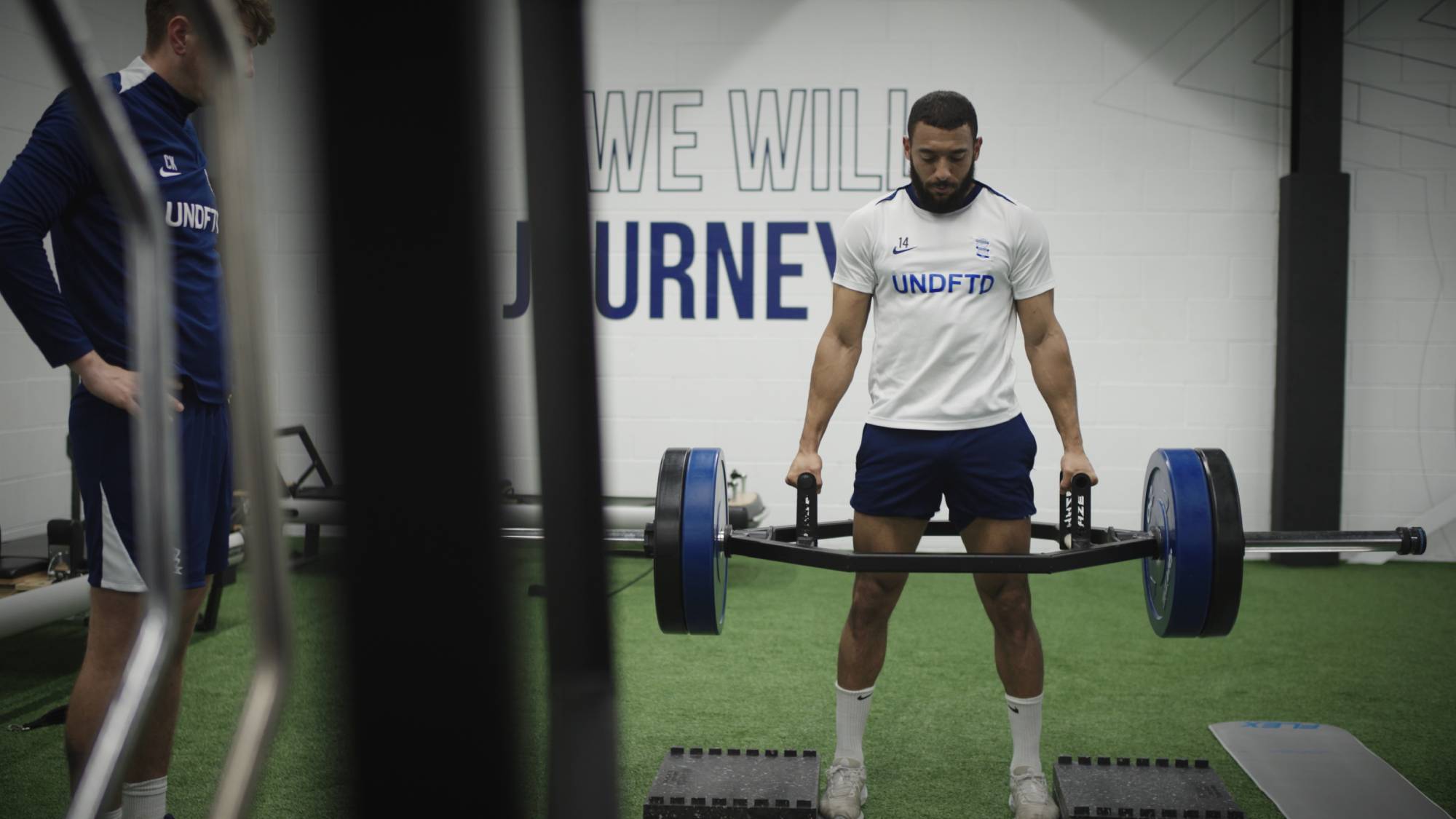 Image from "Built In Birmingham: Brady & the Blues" showing a player lifting weights in the club gym