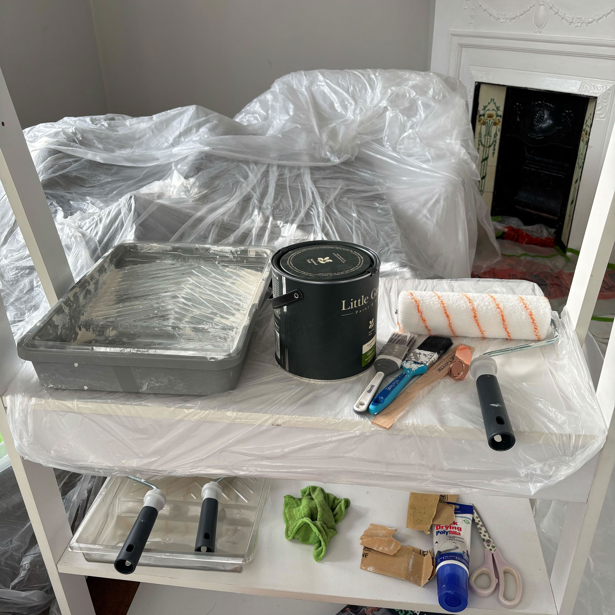 Painting supplies on a table with plastic dust sheets
