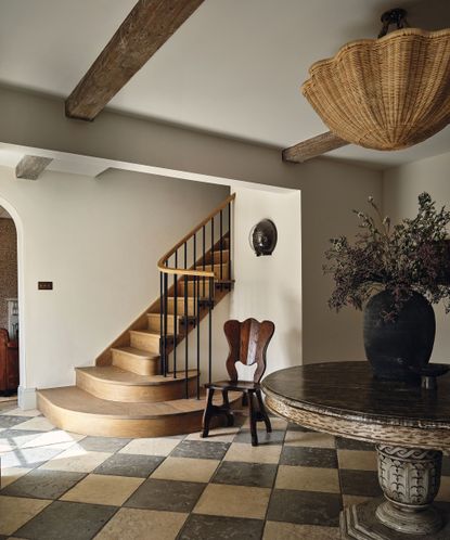 hallway with chequered tiled floor, circular table and rattan pendant light