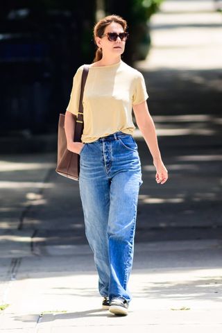 katie holmes wears a butter yellow t-shirt with a madewell bag and jeans while walking in new york city