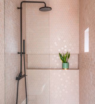 Pink tiled shower with built-in niche and black matt hardware