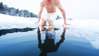 a photo of a man getting in an ice bath