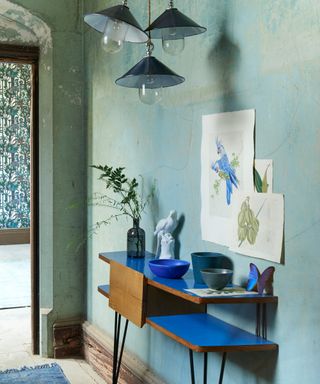 Small hallway ideas with a textured turquoise wall and blue console.