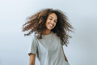 A woman with lots of curly hair smiling at the camera