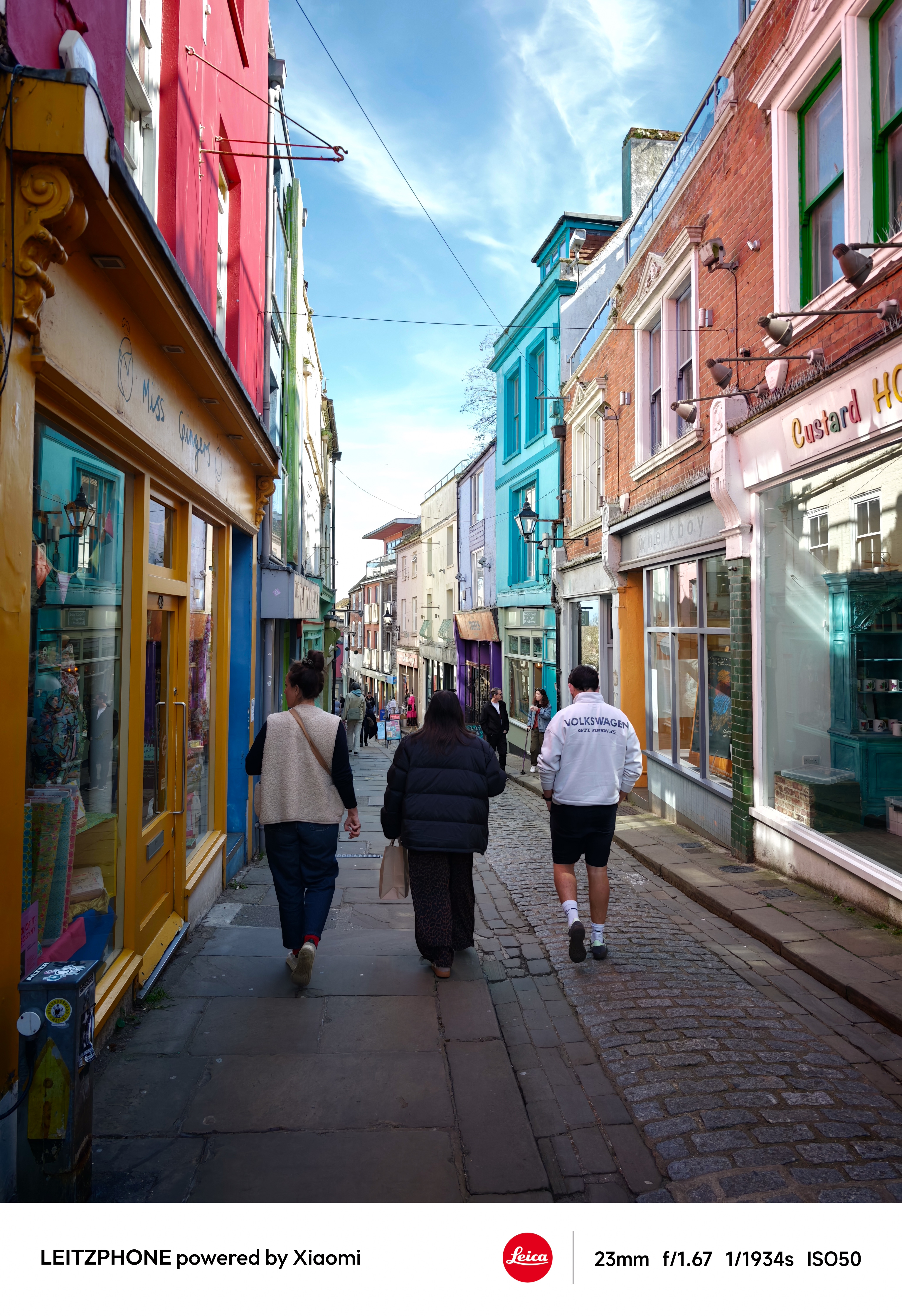 People walking down a colorful cobbled shopping street