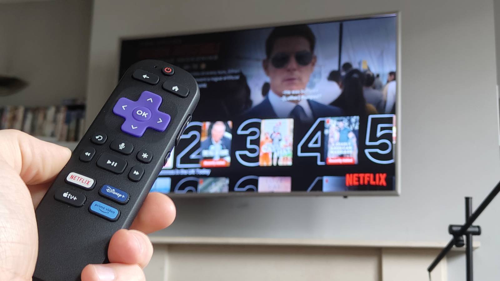 The Roku Streaming Stick remote in front of a TV with Netflix.