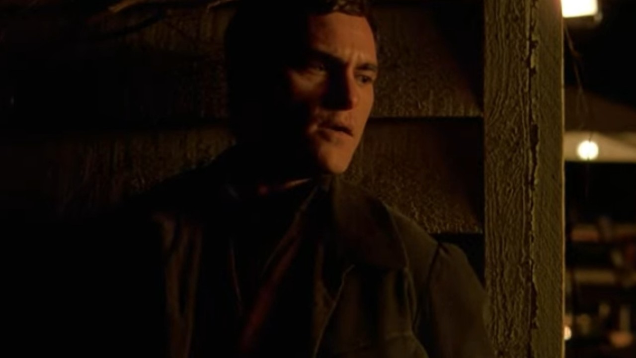 Joaquin Phoenix hiding against a house in The Village