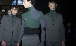 Male models wearing grey suits and green and grey knitwear from the Kris Van Assche AW2015 collection
