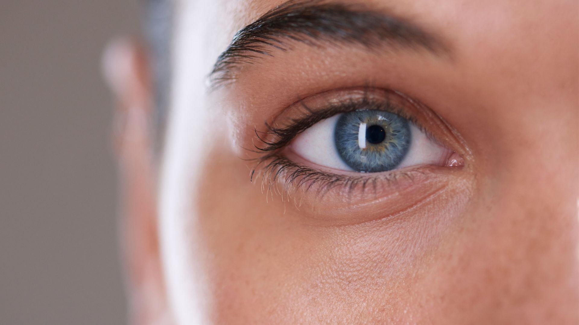 primer plano del ojo azul claro de una mujer, con la plica semilunaris claramente visible