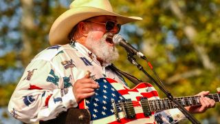 Charlie Daniels onstage with a guitar adorned by the US flag