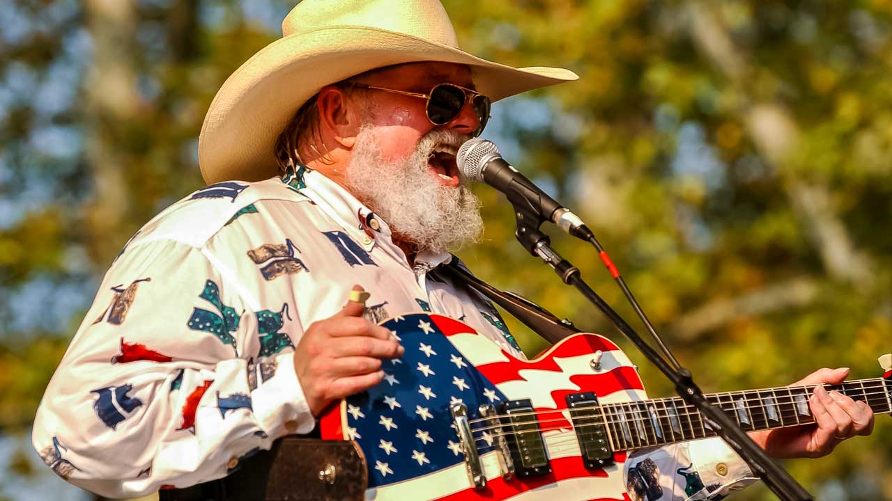 Charlie Daniels onstage with a guitar adorned by the US flag