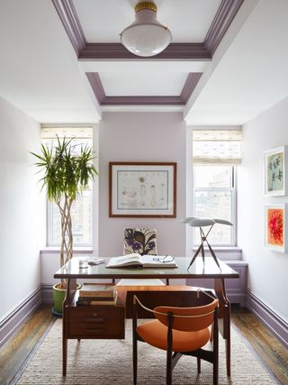 home office in pink and lilac with wood desk and burnt orange chair