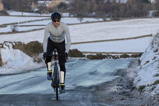 Man wearing a blue top and Sidi Nix shoes riding a Cervelo Caledonia-5 up a snowy lane