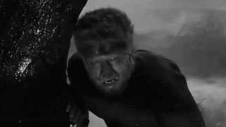 Lon Chaney Jr. as Larry Talbot wolfed out and hiding behind a tree in The Wolf Man