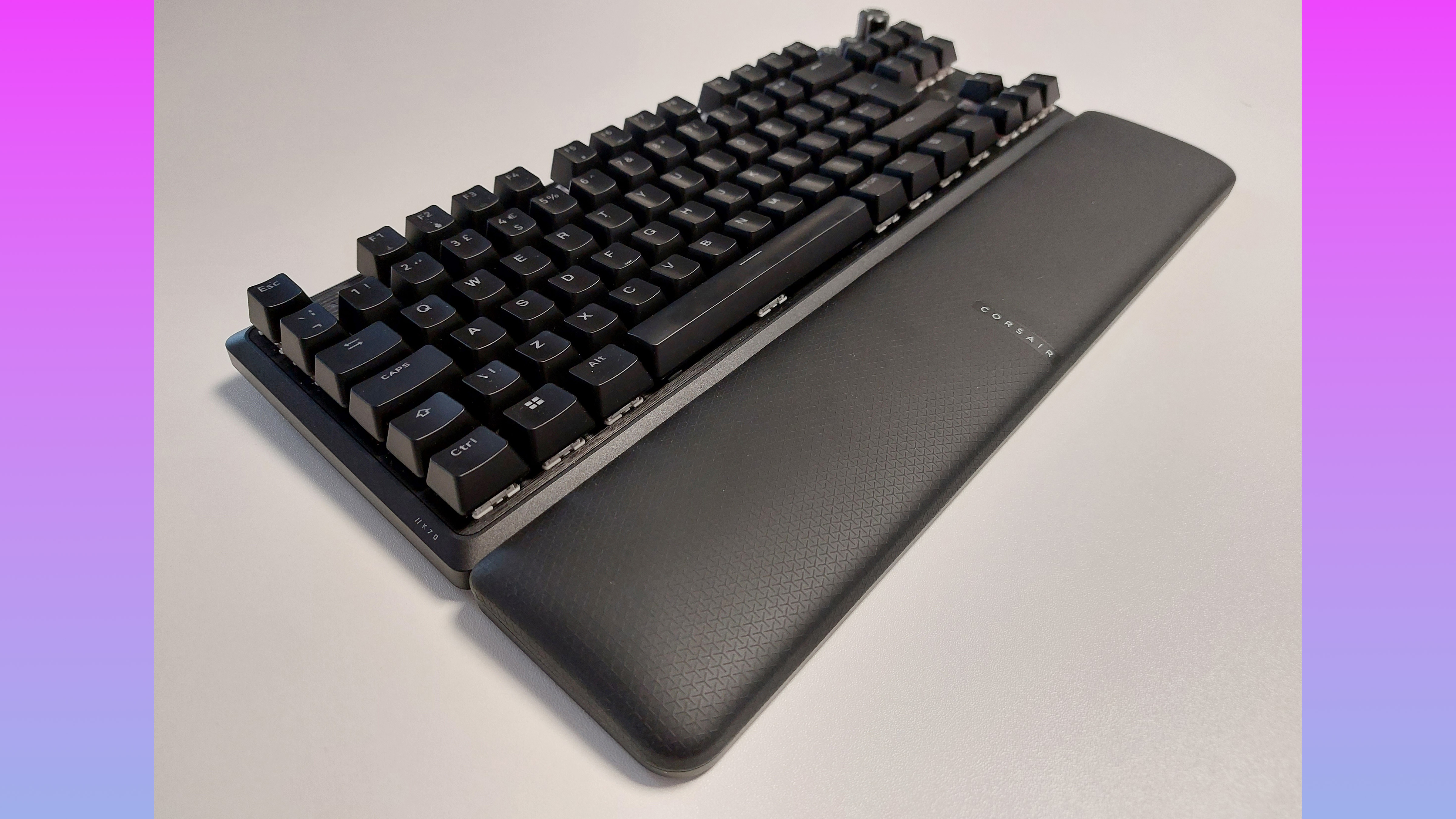 The Corsair K70 Pro TKL gaming keyboard is seen at an angle, with the memory foam leatherette palm wrest pillow magnetically attached along its bottom edge.