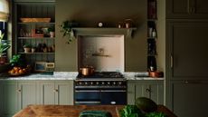 A dark green kitchen with a range alcove