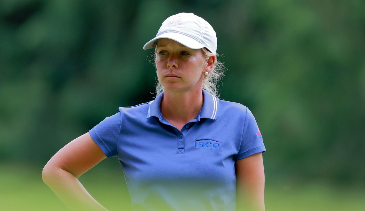 Lauren Hartlage stares on whilst stood on the green