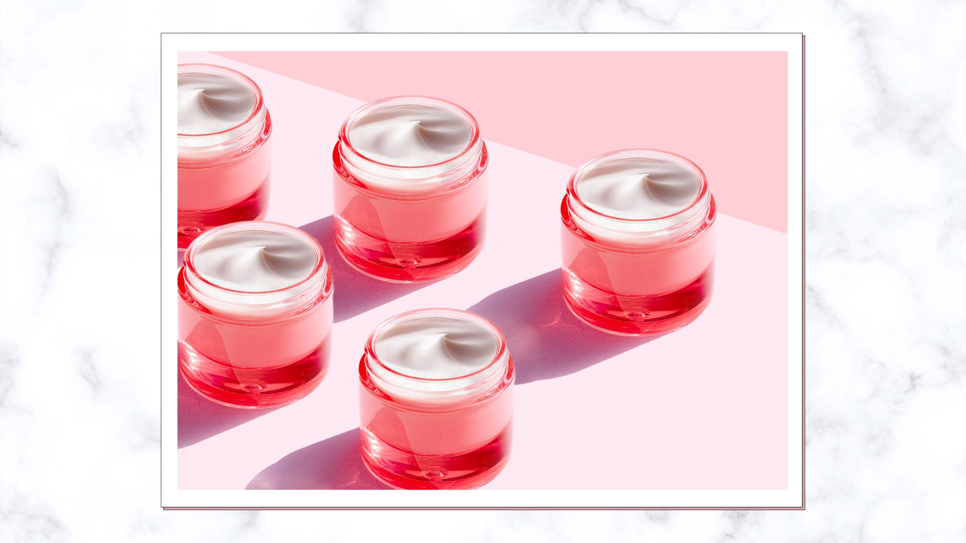 pink pots of moisturiser on marble background