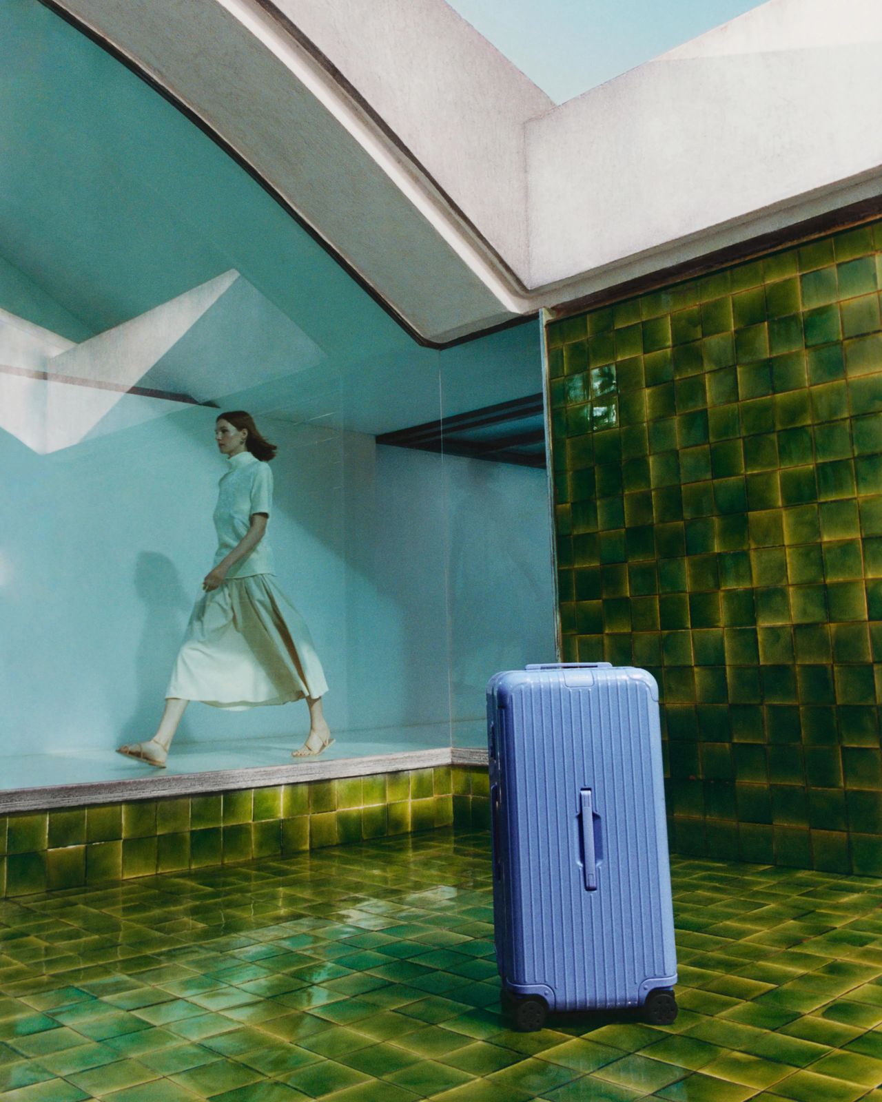 A sea blue minimalist cabin suitacase is captured in multiple sun-lit settings.