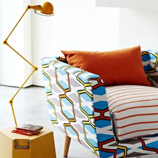 upholstered chair with cushions and beside lamp