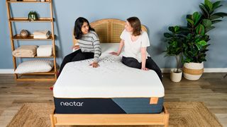 Two Tom's Guide testers sat on the Nectar Ultra Hybrid mattress looking at each other