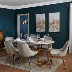 deep blue dining room with table and wall art
