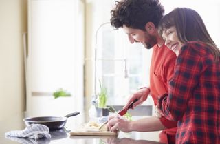 Couple smiling and cooking together