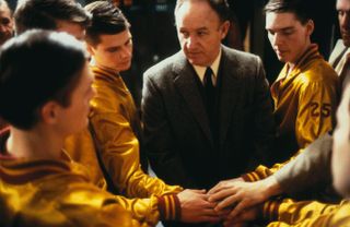 teenage basketball players get ready and amp up before a game with their coach in hoosiers