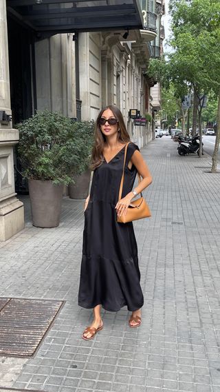 Felicia Akerstrom posing in a black dress and crossbody bag