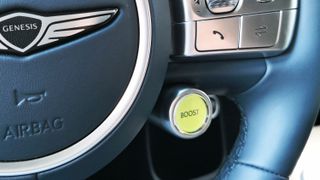 Close-up of green boost button on steering wheel