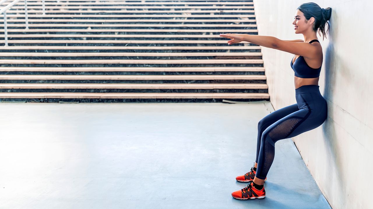 Woman doing glute exercises wall sit