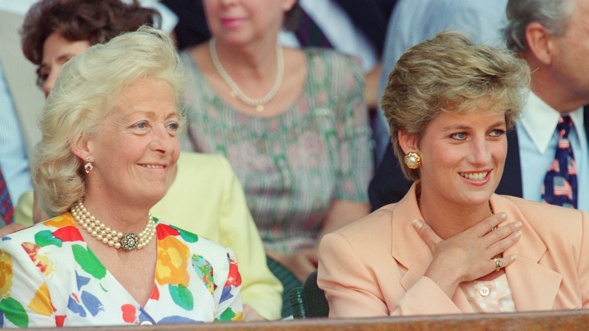 Frances Shand Kydd wearing a floral dress sitting next to Princess Diana wearing a peach suit