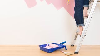 Lady painting a wall with wrong footwear