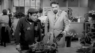 Jonathan Haze and Mel Welles as Seymour and Gravis looking down at a Venus Fly Trap in The Little Shop of Horrors 1960 b&w movie