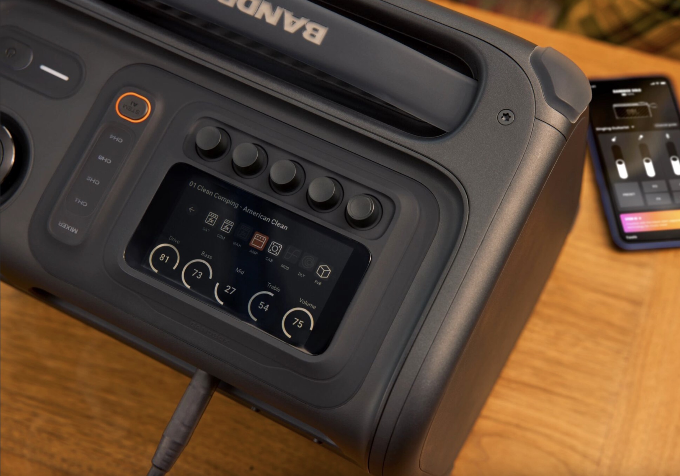 JBL's BandBox Trio sits on a table, with an iPhone to its right