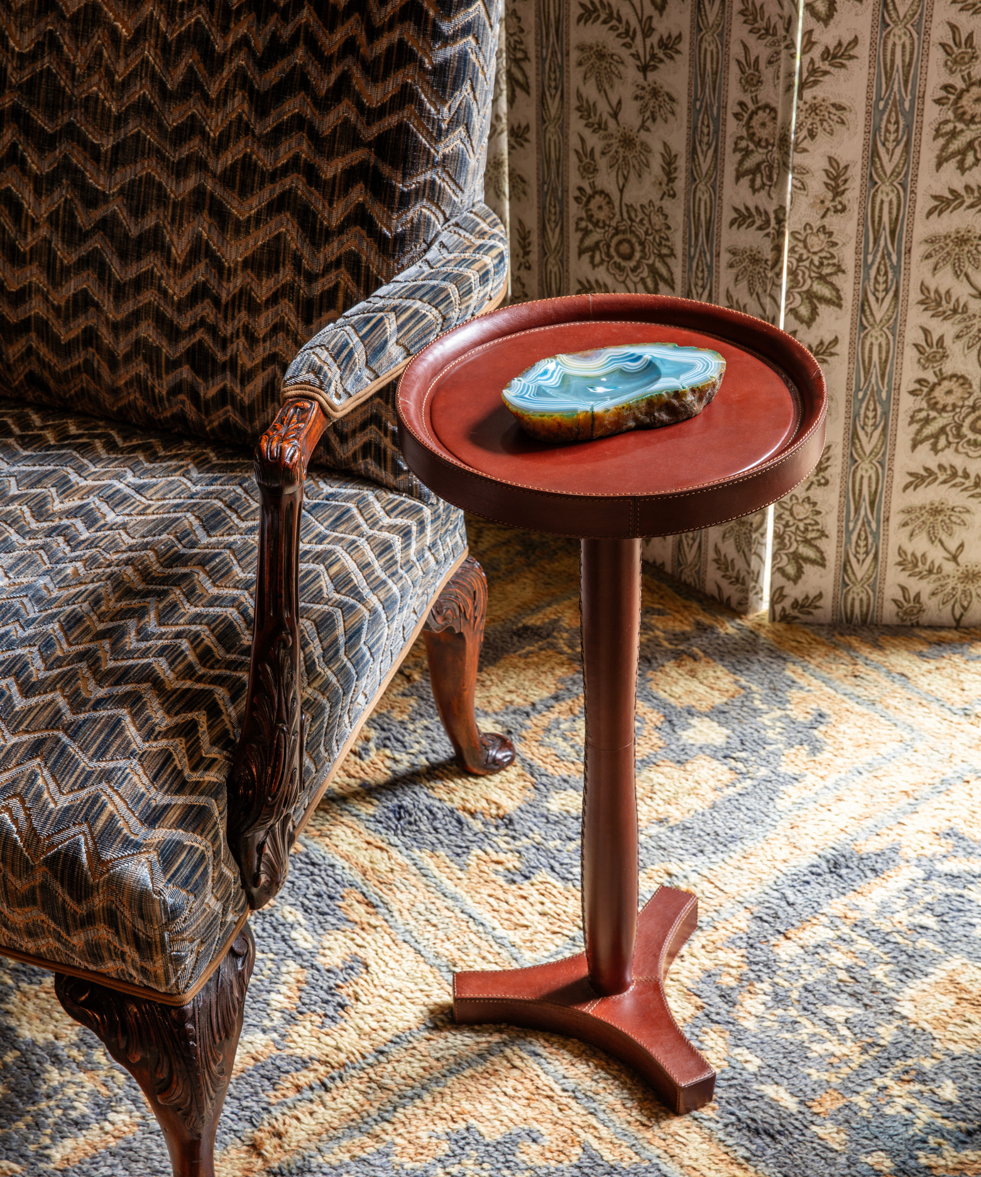 Pattern-drenched living room vignette featuring an oxblood lacquer side table