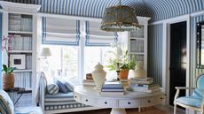 Blue and white striped living room with wallpaper, bench and chair matching and round white coffee table
