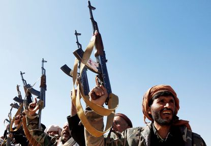 Houthi followers lift rifles and shout slogans against the U.S.-U.K. during a tribal gathering on January 14, 2024 on the outskirts of Sana'a, Yemen. Houthi followers gathered to protest against the U.S.-U.K. airstrikes on positions in areas under their control.