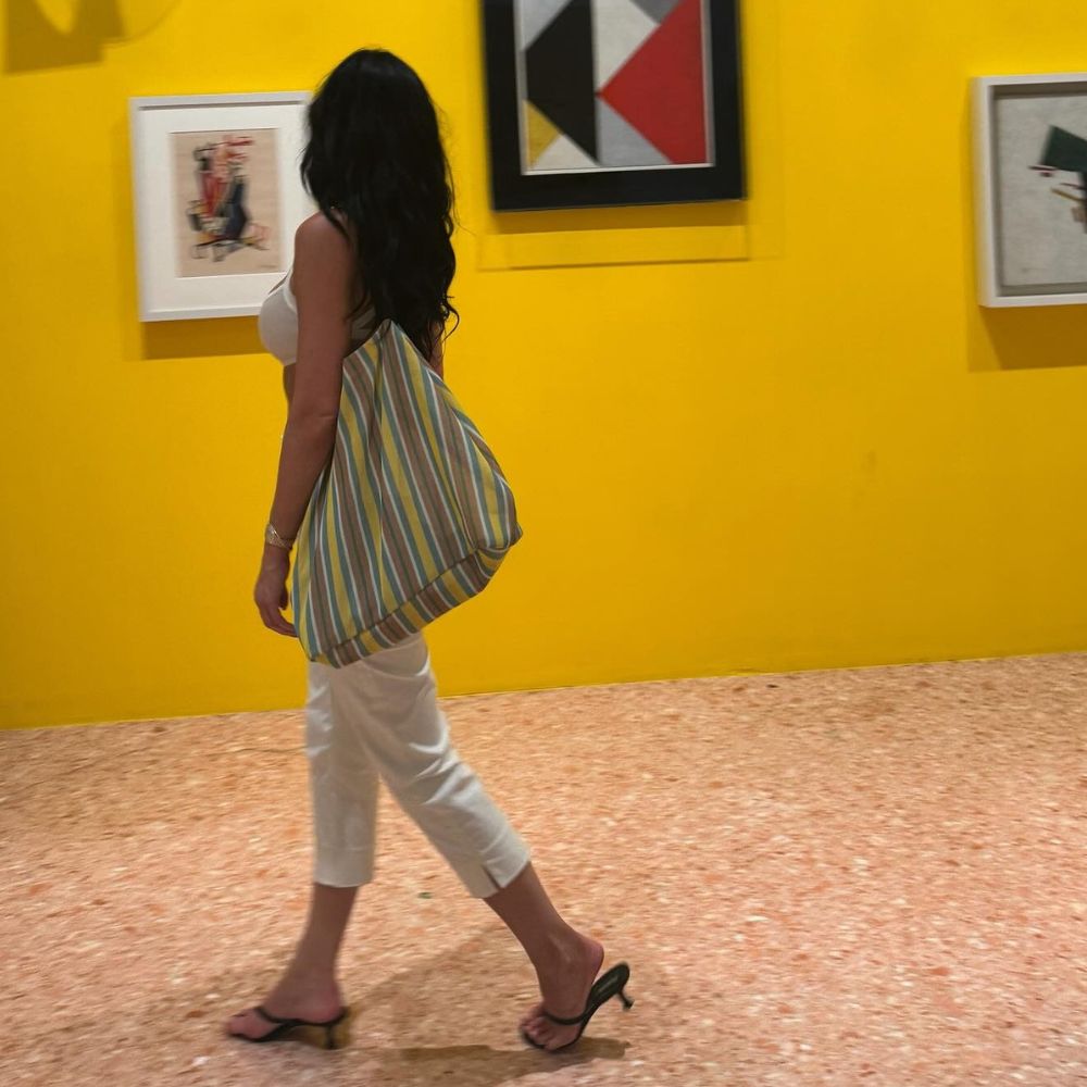Kylie Jenner wears The Row Barn Bag slung over her shoulder in a museum.
