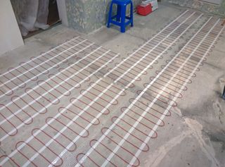 Electric underfloor heating on matting laid out on a concrete floor