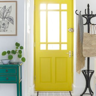 White hallway with bright yellow front door