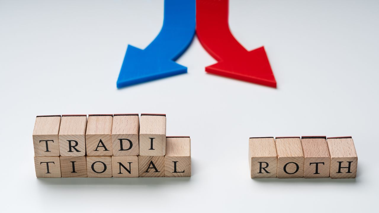 &quot;Traditional&quot; and &quot;Roth&quot; are written on wooden blocks below red and blue arrows pointing in different directions.