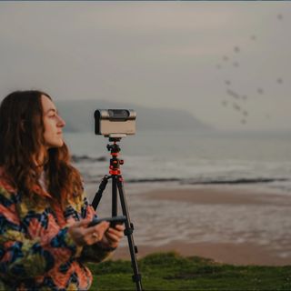 A woman using a Dwarf 3 smart telescope for bird watching