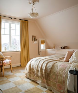 blush pink bedroom with yellow checked rug and yellow curtains