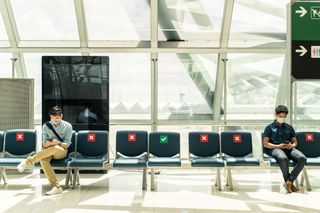 People social distancing at an airport.