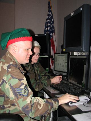 Two members of NORAD's Northeast Air Defense Sector get ready to track Santa Claus using radar equipment in December 2008 . 