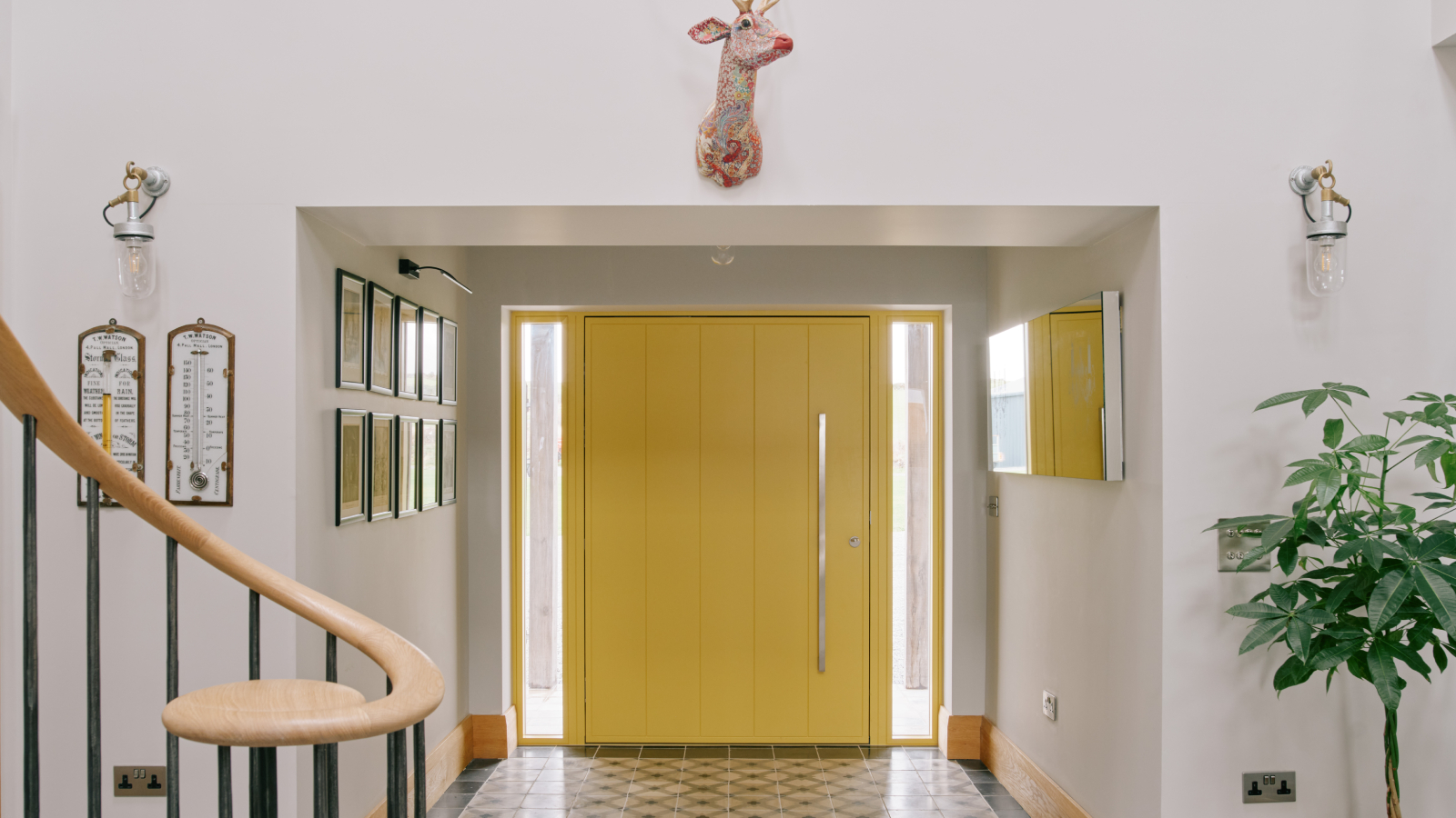 large yellow modern door with aluminum long handle viewed from inside hallway with white walls and tiled floor