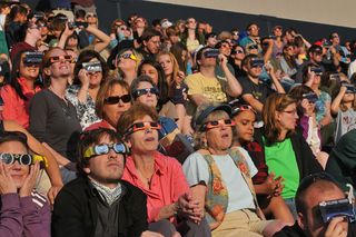 Spectators in special solar eclipse glasses stare at the sun during the annular solar eclipse on May 20, 2012. The observers attended a special event held at the University of Colorado's Folsom Field football stadium in Boulder, Colo.